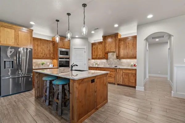 a kitchen with kitchen island a sink stove and refrigerator