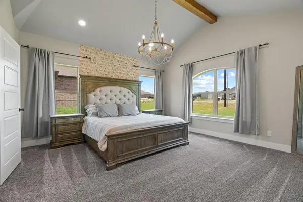 a spacious bedroom with a bed and a chandelier