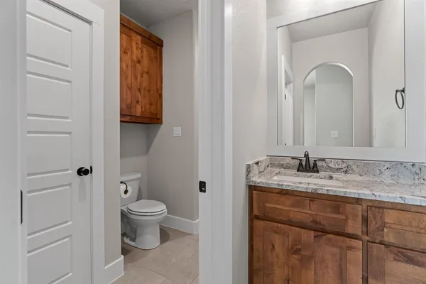 a bathroom with a granite countertop sink a toilet and a mirror