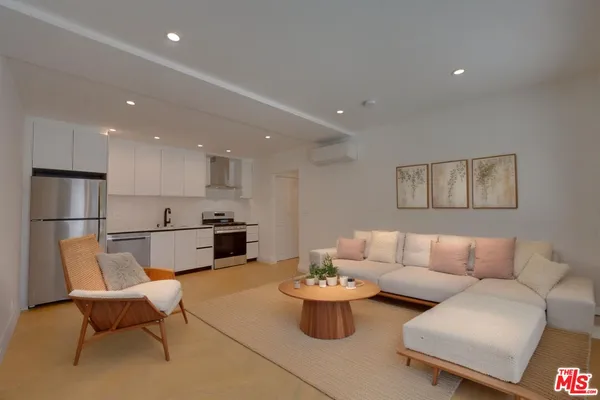 a living room with furniture and kitchen view