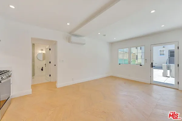 an empty room with mirror and windows