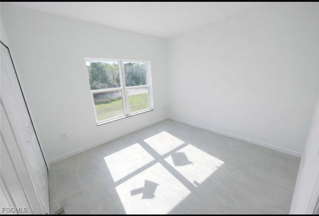 3121 24th Street Southwest Lehigh Acres, FL 33976 - Photo 6 of 10 an empty room with a window