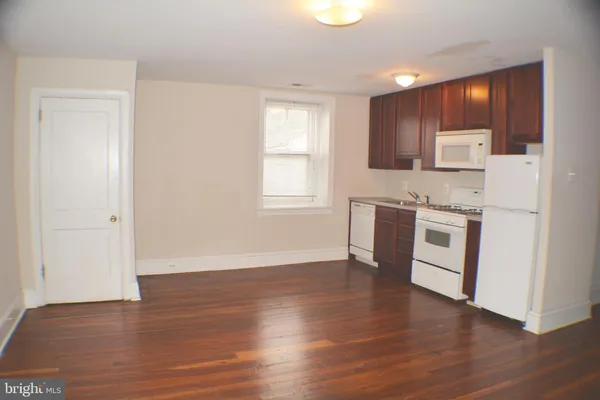 a kitchen with wooden floors and stainless steel appliances