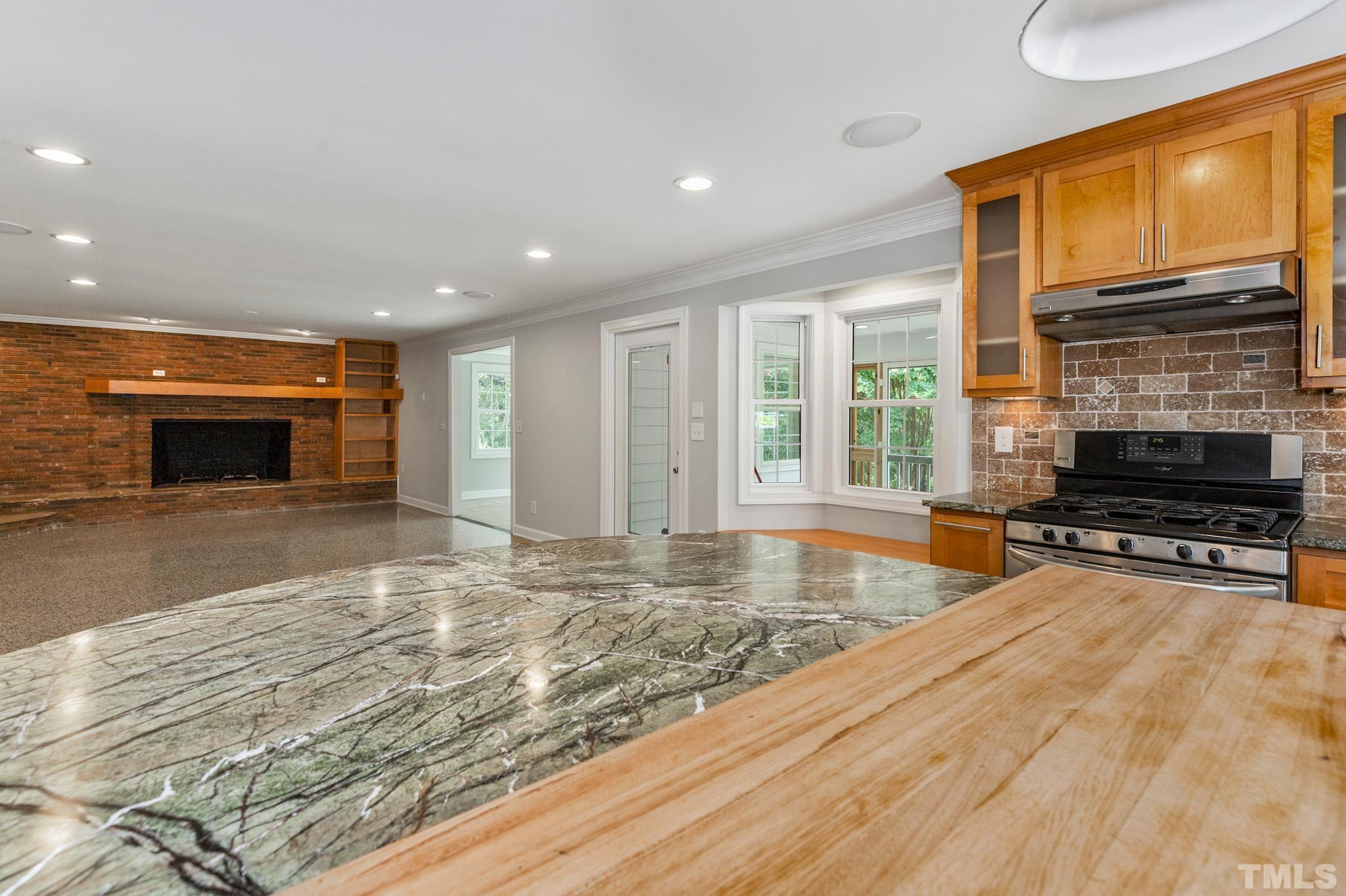 6630 Winding Trail Raleigh, NC 27612 - Photo 11 of 33 a view of open kitchen with wooden floor and a fireplace