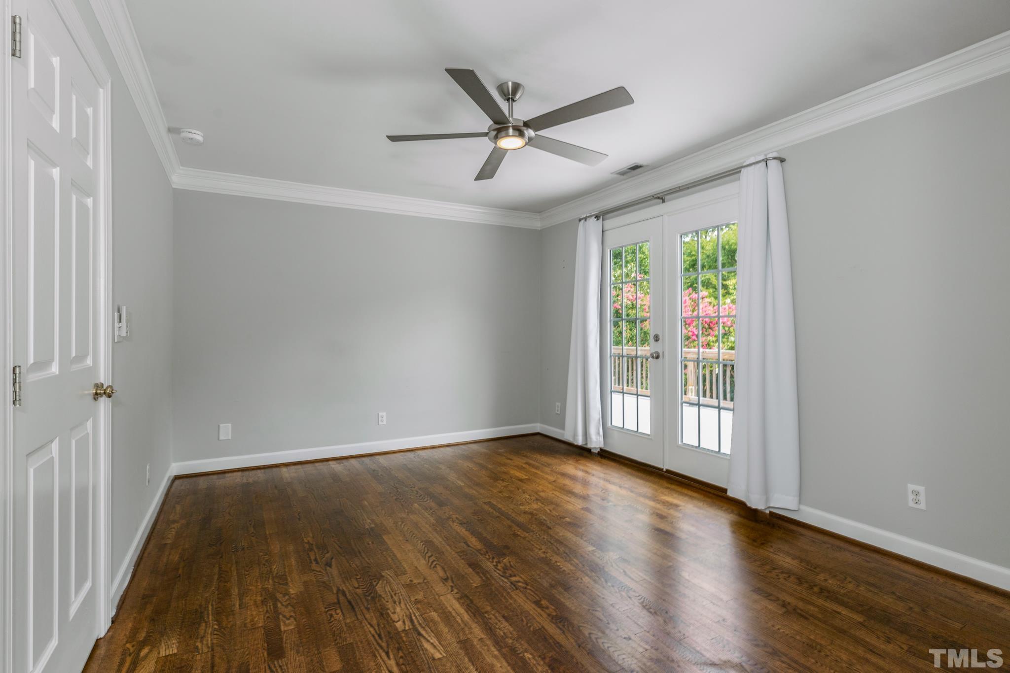 6630 Winding Trail Raleigh, NC 27612 - Photo 19 of 33 an empty room with wooden floor fan and windows