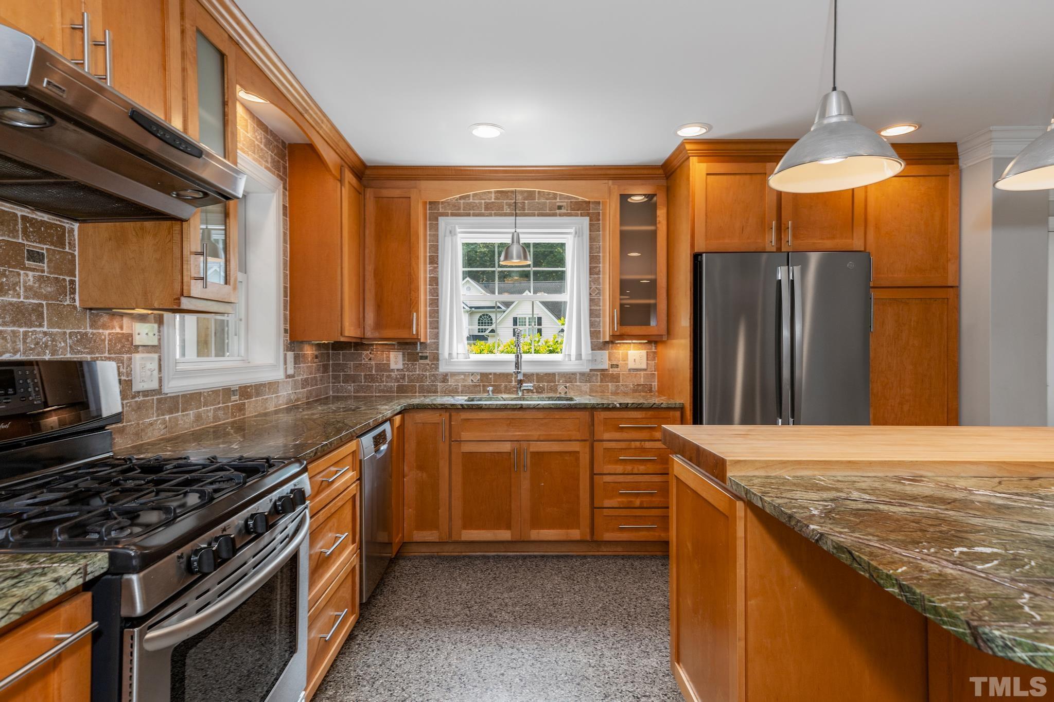 6630 Winding Trail Raleigh, NC 27612 - Photo 9 of 33 a kitchen with stainless steel appliances granite countertop a stove a refrigerator and a sink