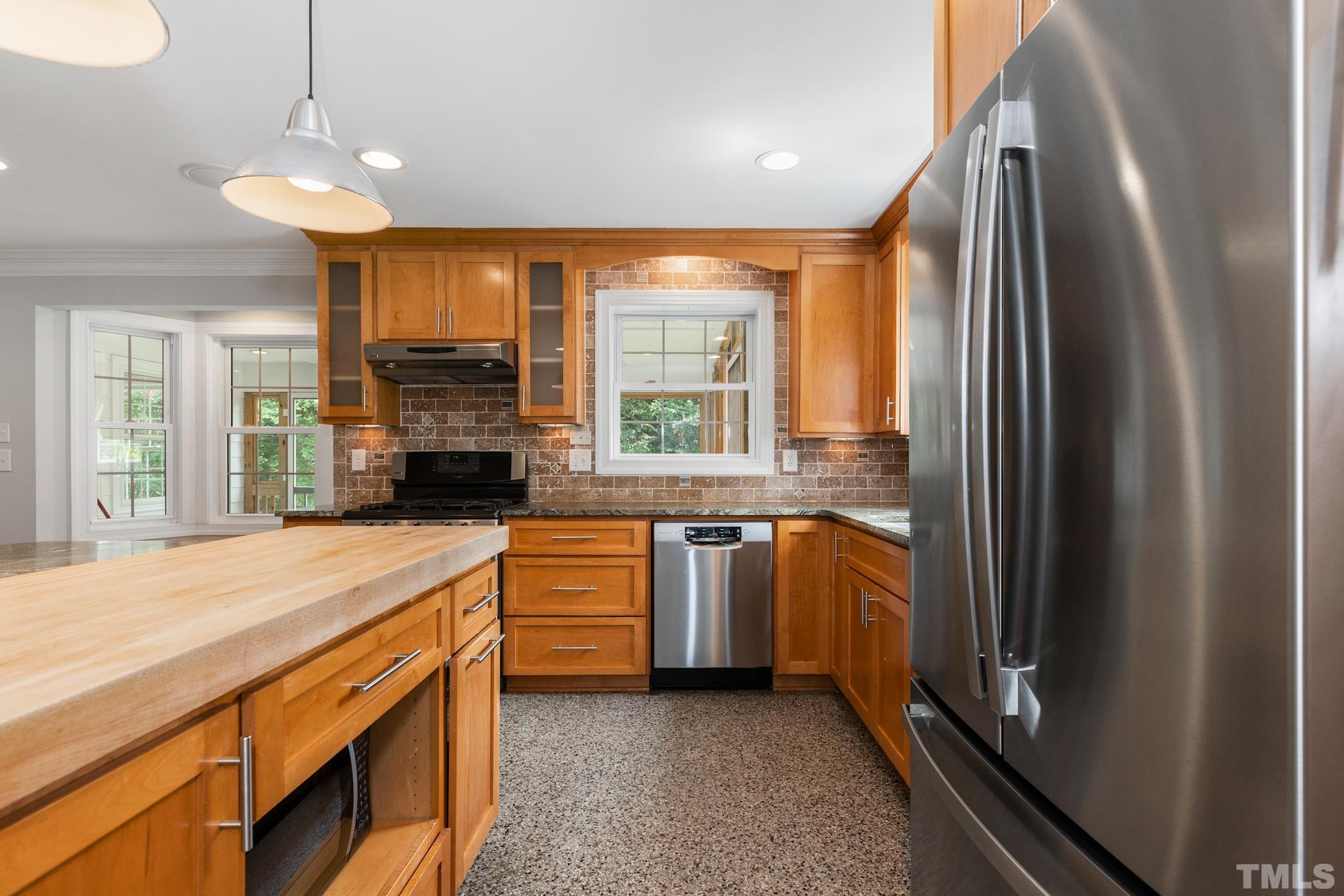 6630 Winding Trail Raleigh, NC 27612 - Photo 10 of 33 a kitchen with stainless steel appliances granite countertop a refrigerator a sink dishwasher a stove and a flat screen tv