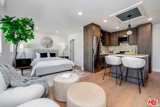 a bed room with a bed a couch and a potted plant