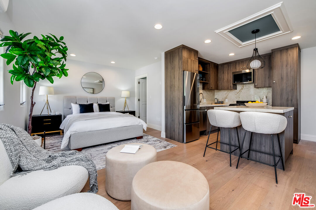 4359 Clybourn Avenue Toluca Lake, CA 91602 - Photo 31 of 45 a bed room with a bed a couch and a potted plant