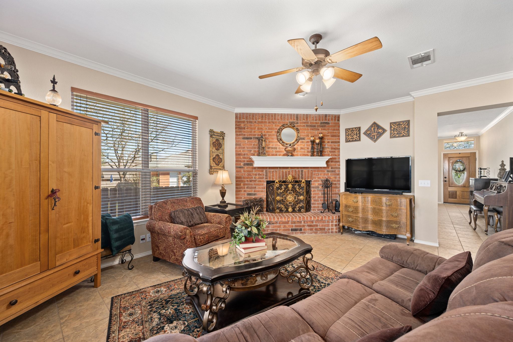3312 Marin Court Austin, TX 78738 - Photo 14 of 40 A warm and welcoming family room is centered around a cozy fireplace framed in a classic brick hearth with a wood mantel above.