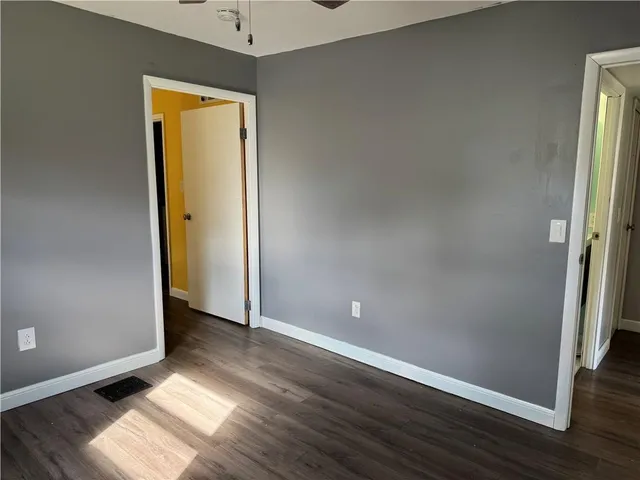 an empty room with wooden floor and entrance
