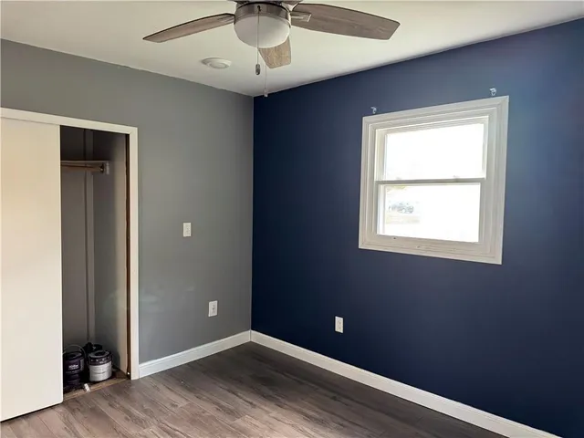 an empty room with a window and wooden floor
