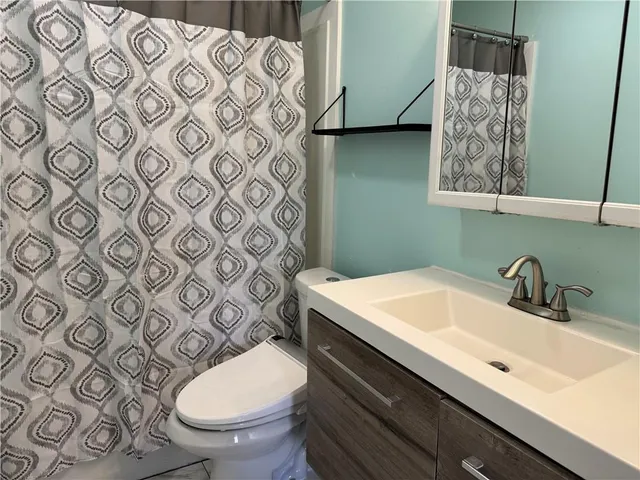 a bathroom with a sink mirror vanity and toilet