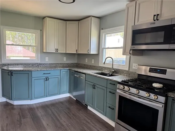 a kitchen with granite countertop wooden cabinets and a stove top oven