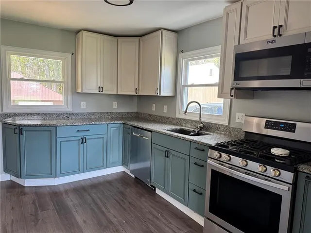 a kitchen with granite countertop wooden cabinets and a stove top oven