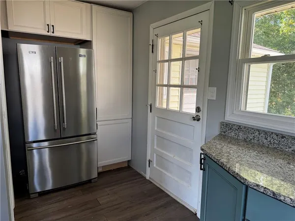 a kitchen with granite countertop stainless steel appliances a refrigerator and cabinets