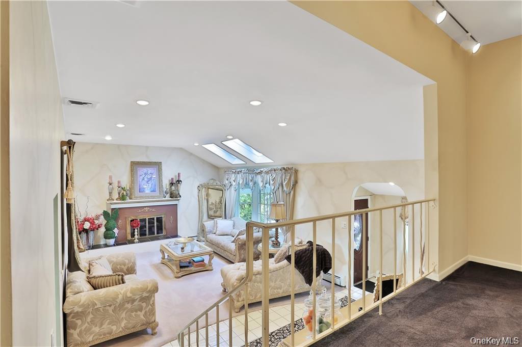 2 Split Tree Drive New Windsor, NY 12553 - Photo 13 of 36 Living room featuring a skylight, rail lighting, dark carpet, baseboard heating, and recessed lighting