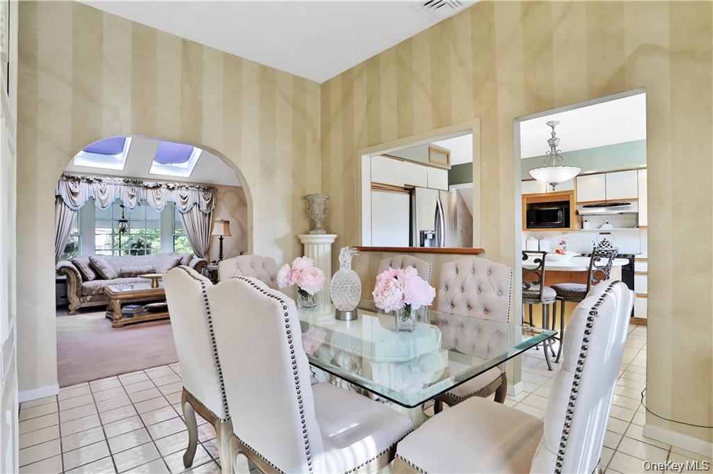 2 Split Tree Drive New Windsor, NY 12553 - Photo 15 of 36 Dining area with arched walkways, light tile patterned floors, and wallpapered walls