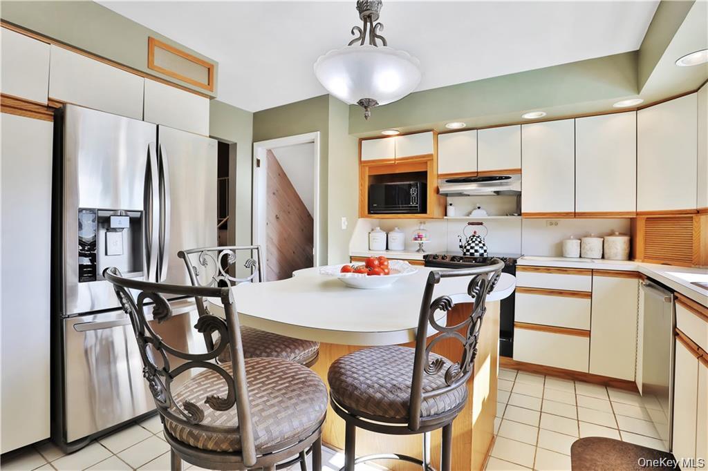 2 Split Tree Drive New Windsor, NY 12553 - Photo 18 of 36 Kitchen featuring stainless steel appliances, light countertops, white cabinetry, and pendant lighting