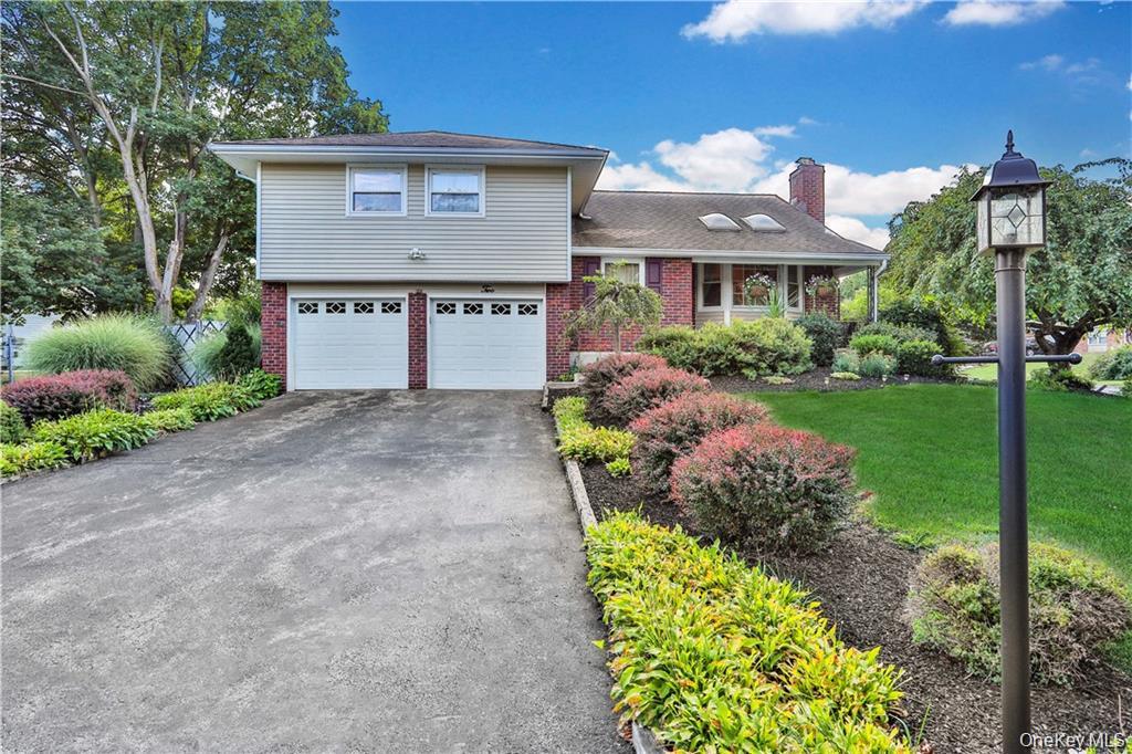 2 Split Tree Drive New Windsor, NY 12553 - Photo 36 of 36 Split level home with brick siding, a garage, driveway, a front lawn, and a chimney