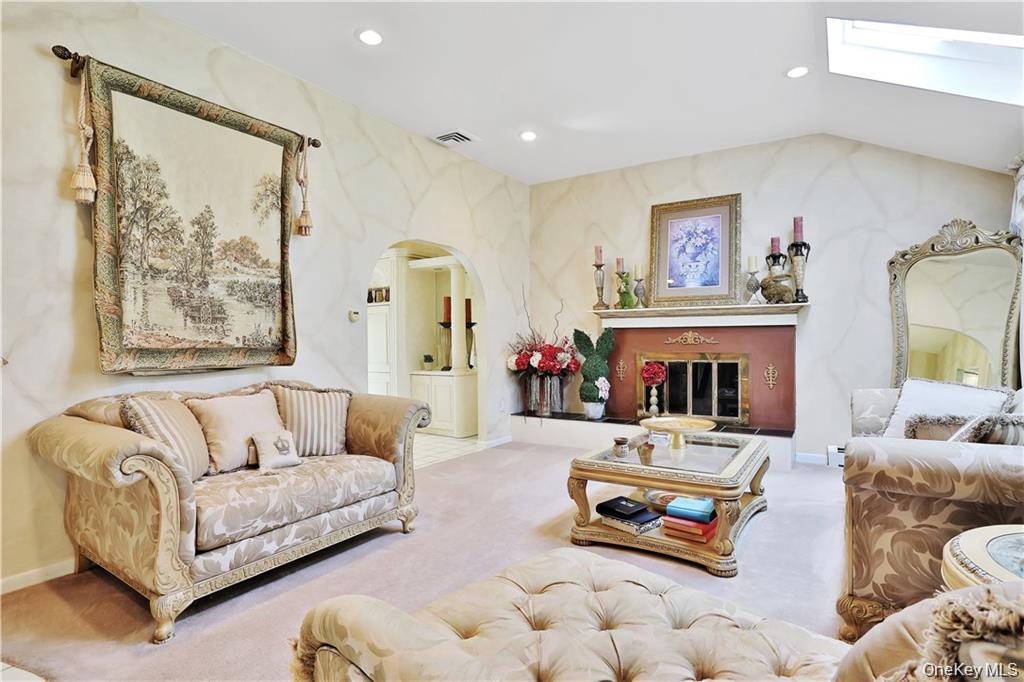 2 Split Tree Drive New Windsor, NY 12553 - Photo 9 of 36 Living room featuring recessed lighting, a skylight, arched walkways, a glass covered fireplace, and carpet