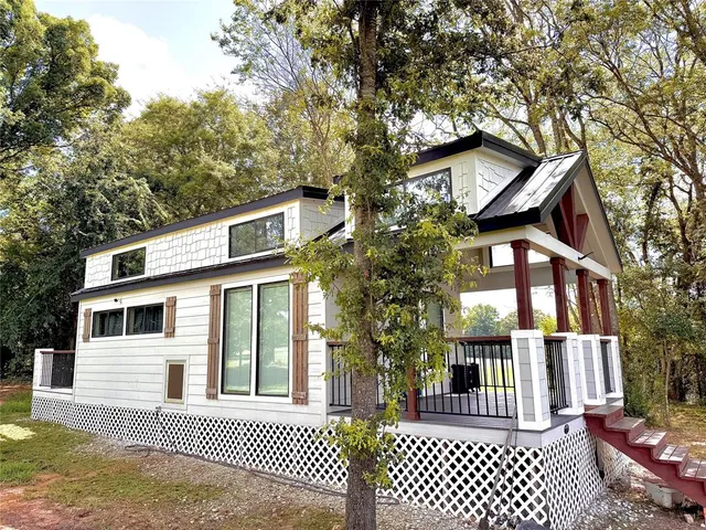 a kitchen with stainless steel appliances a stove a sink dishwasher a refrigerator white cabinets and wooden floor