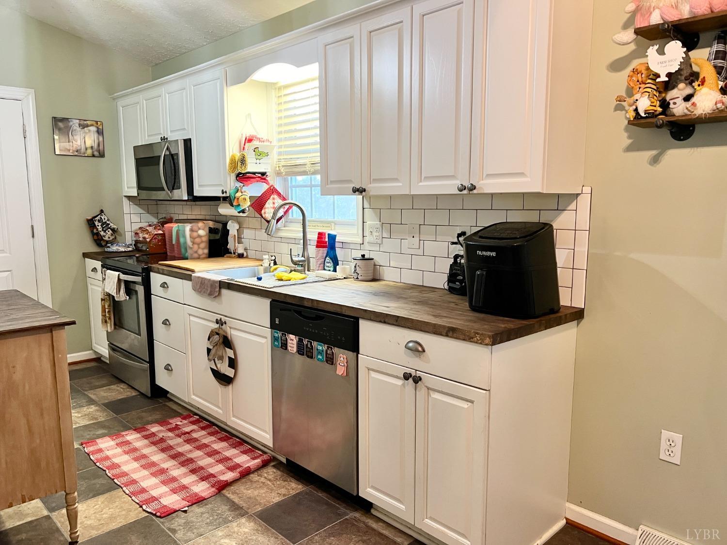 499 Reedy Spring Road Spout Spring, VA 24593 - Photo 14 of 66 a kitchen with stainless steel appliances a stove a sink and a microwave
