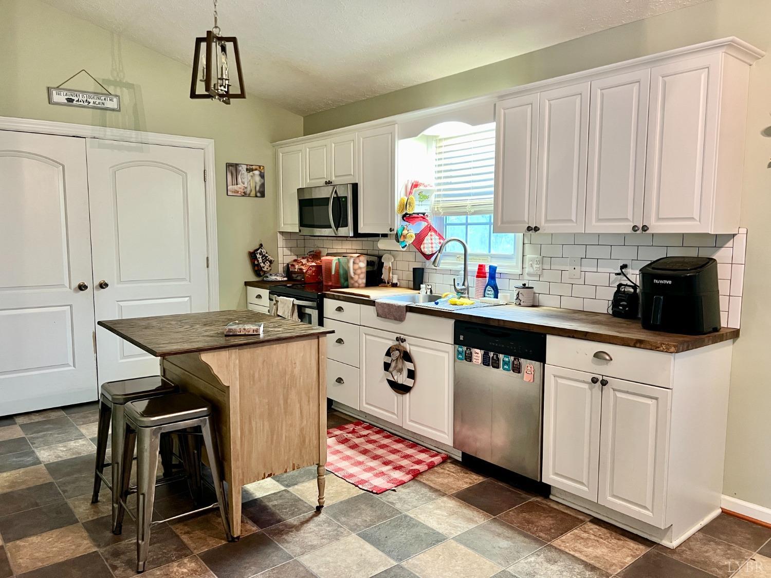 499 Reedy Spring Road Spout Spring, VA 24593 - Photo 15 of 66 a kitchen with stainless steel appliances a sink a stove a table and chairs