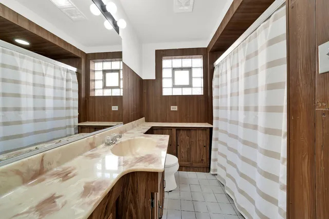 a bathroom with a granite countertop sink and a bathtub