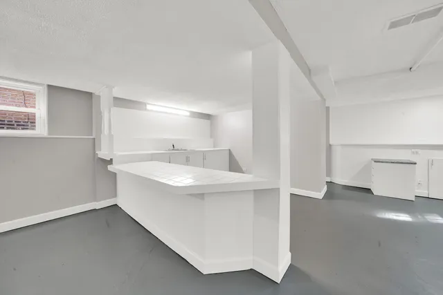 a view of a big room with windows and chandelier fan