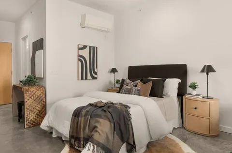 a bedroom with a bed and wooden floor