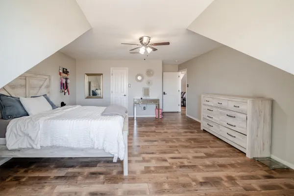 a kitchen with granite countertop a stove a sink a refrigerator and wooden floor