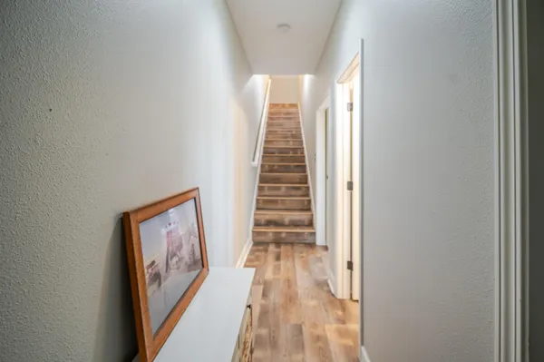 a view of a hallway with wooden floor and closet area