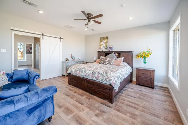 a kitchen with stainless steel appliances granite countertop a stove top oven a sink dishwasher and white cabinets with wooden floor