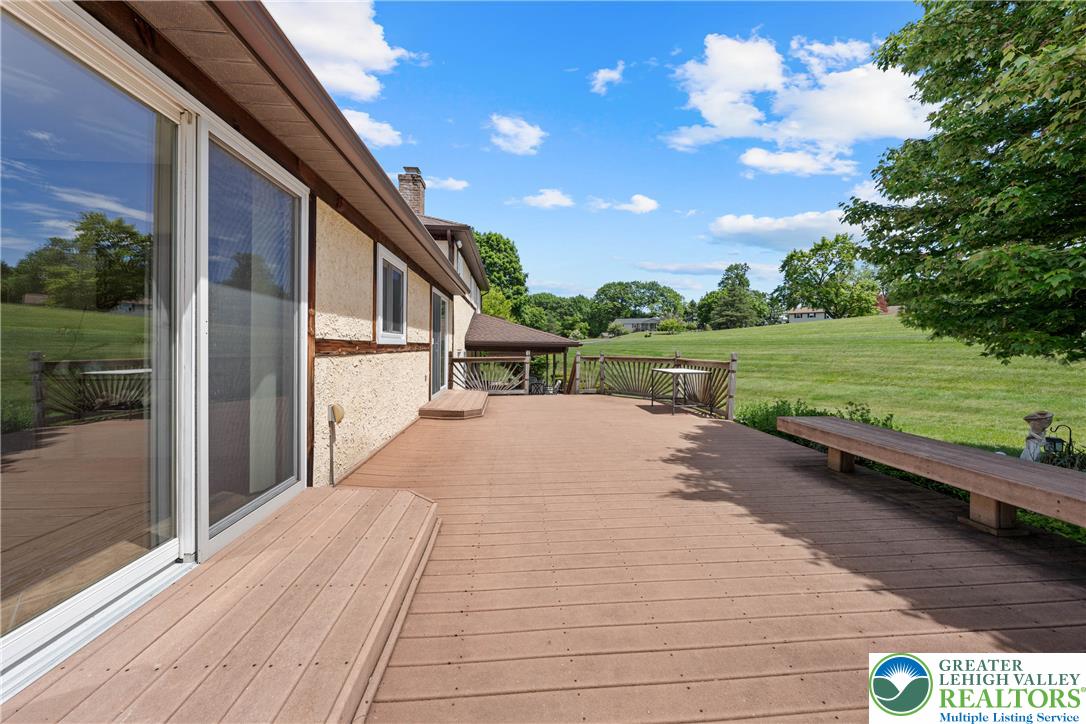 947 Tamenend Road Bath, PA 18014 - Photo 38 of 61 An expansive outdoor deck offers abundant space for entertaining and overlooks a serene, verdant landscape.