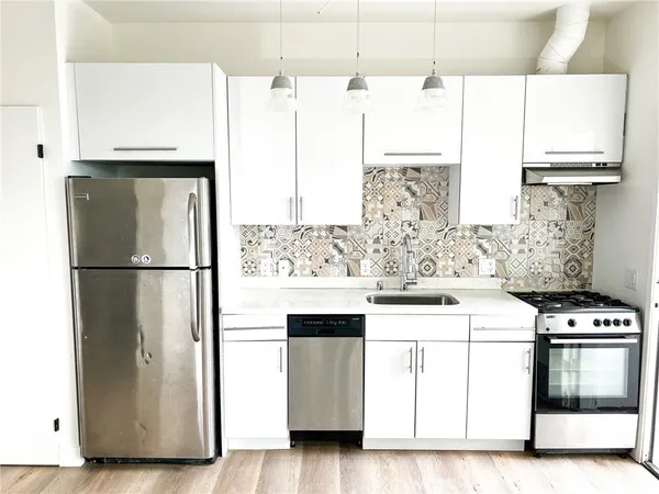 a kitchen with stainless steel appliances a refrigerator sink and cabinets