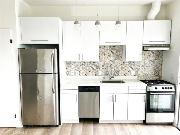 a kitchen with stainless steel appliances a refrigerator sink and cabinets