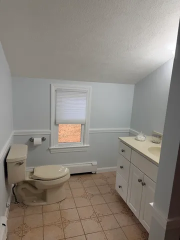 a bathroom with a toilet a sink and mirror