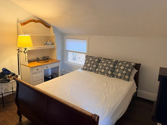 a bed sitting in a bedroom next to a window