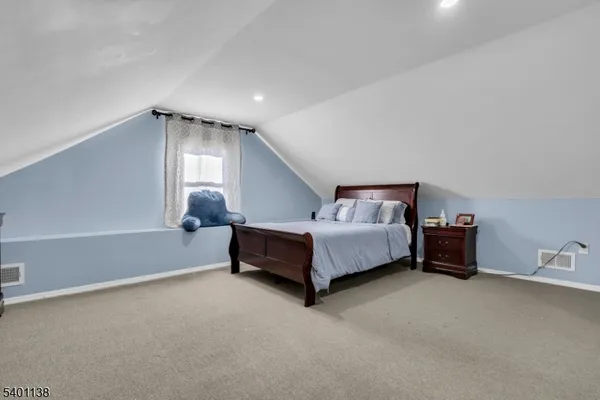 a spacious bedroom with a bed and a dresser