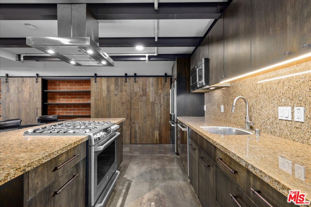 120 South Hewitt Street, Unit 6 Los Angeles, CA 90012 - Photo 15 of 48 a kitchen with granite countertop a sink and stove