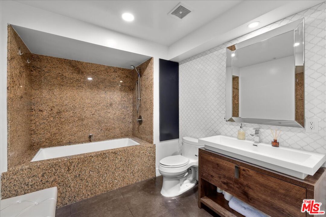 120 South Hewitt Street, Unit 6 Los Angeles, CA 90012 - Photo 18 of 48 a bathroom with a bathtub shower sink mirror and toilet