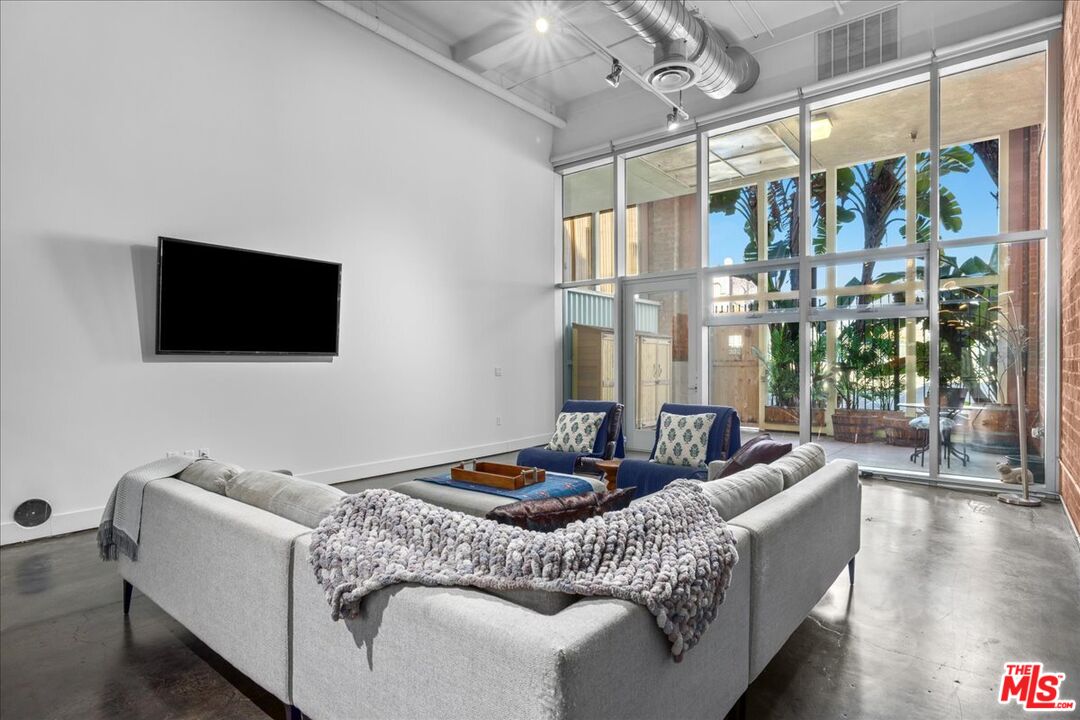 120 South Hewitt Street, Unit 6 Los Angeles, CA 90012 - Photo 2 of 48 a living room with furniture and a flat screen tv