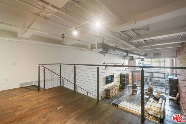 a view of a hallway with wooden floor and furniture