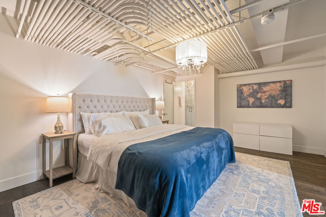 120 South Hewitt Street, Unit 6 Los Angeles, CA 90012 - Photo 27 of 48 a bedroom with a bed and a chandelier