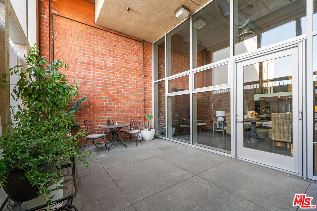 120 South Hewitt Street, Unit 6 Los Angeles, CA 90012 - Photo 39 of 48 a view of a patio with table and chairs and potted plants