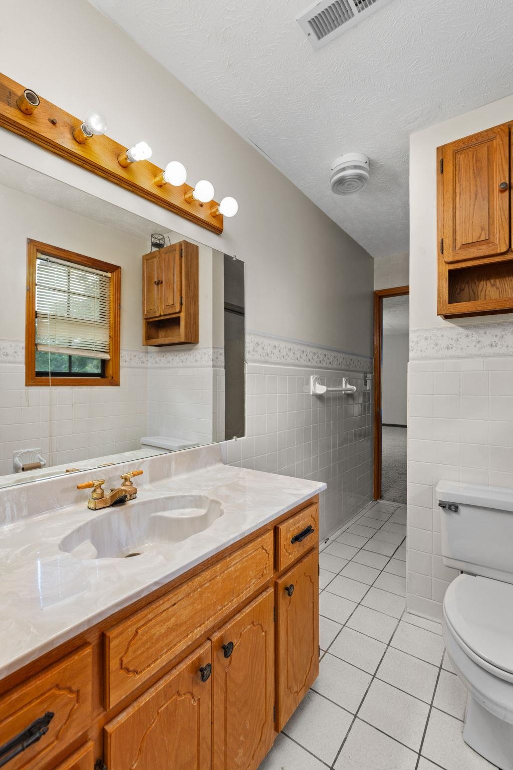 165 Highway 201 Reagan, TN 38368 - Photo 15 of 40 Bathroom with light tile patterned floors, tile walls, vanity, a wainscoted wall, and a textured ceiling