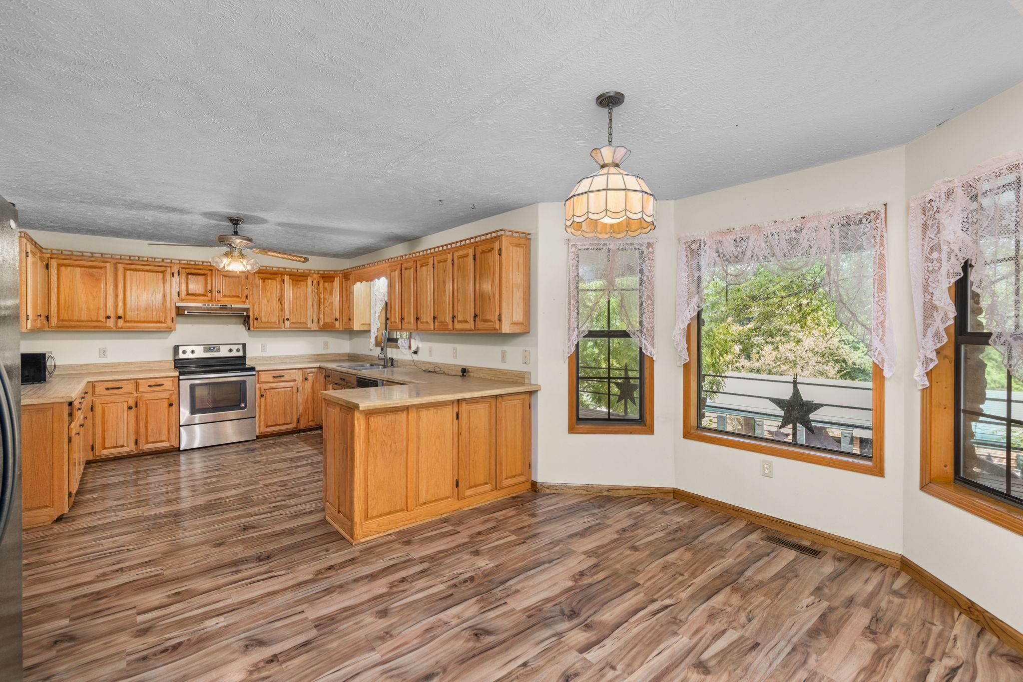 165 Highway 201 Reagan, TN 38368 - Photo 17 of 40 a large kitchen with stainless steel appliances granite countertop a stove a sink dishwasher a microwave oven with cabinets and wooden floor