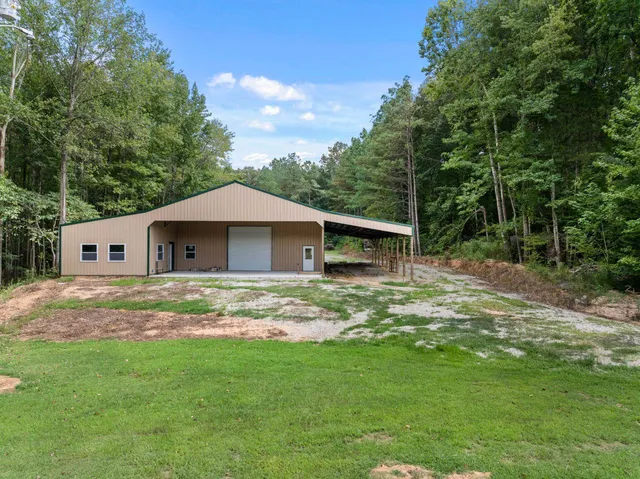 a backyard of a house with wooden fence and large trees