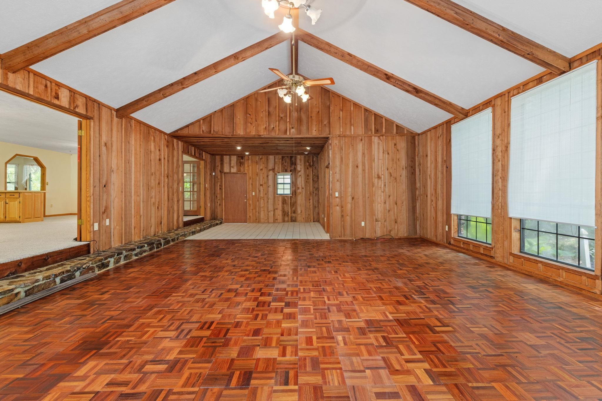 165 Highway 201 Reagan, TN 38368 - Photo 33 of 40 Unfurnished living room featuring healthy amount of natural light, wood walls, beam ceiling, high vaulted ceiling, and a ceiling fan